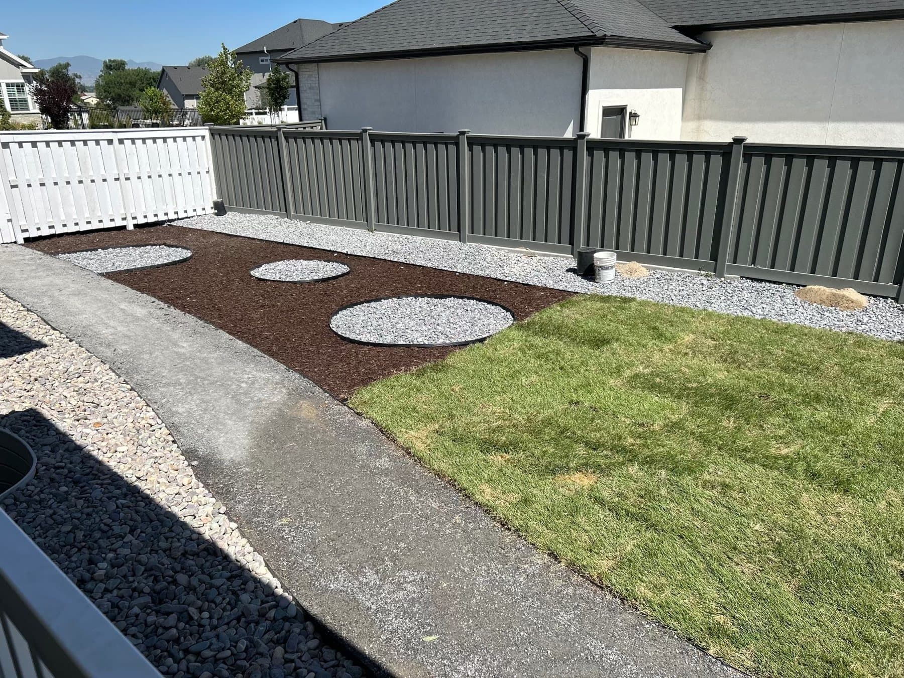 Dark composite privacy fence with landscaping and mountain views