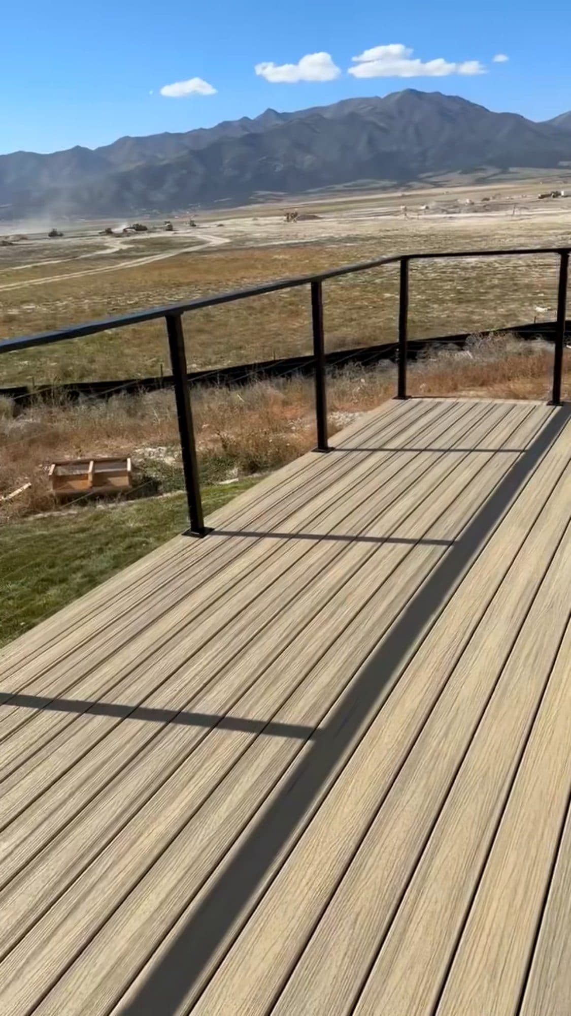 Composite deck with black metal railing overlooking the valley
