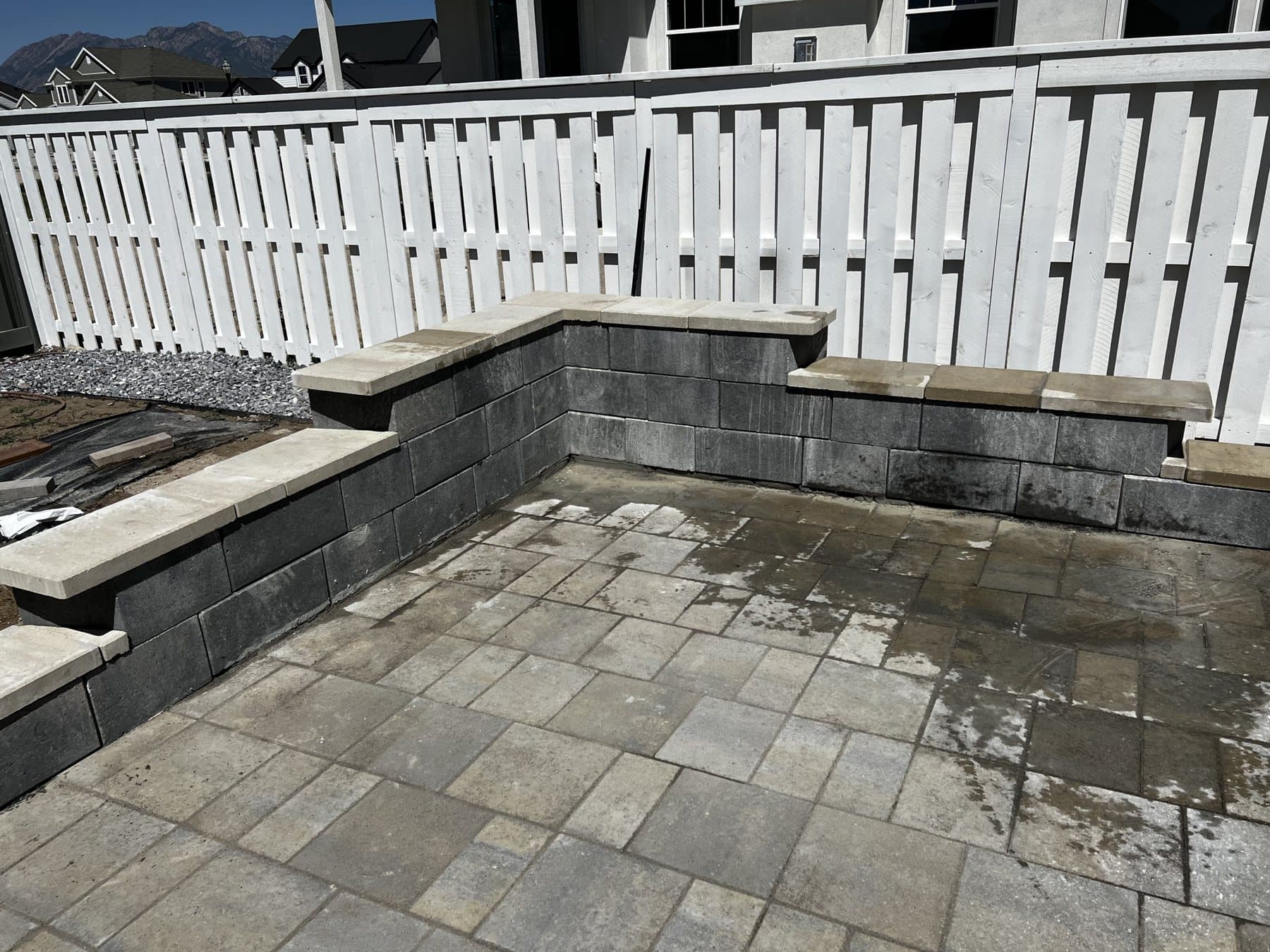 White semi-privacy vinyl fence around a new paver patio