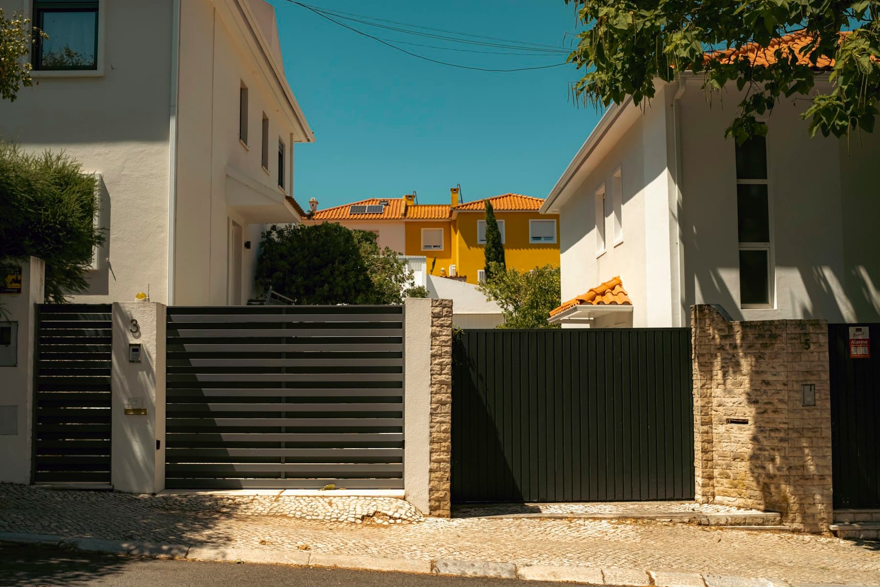 Modern horizontal-slat driveway gate between homes