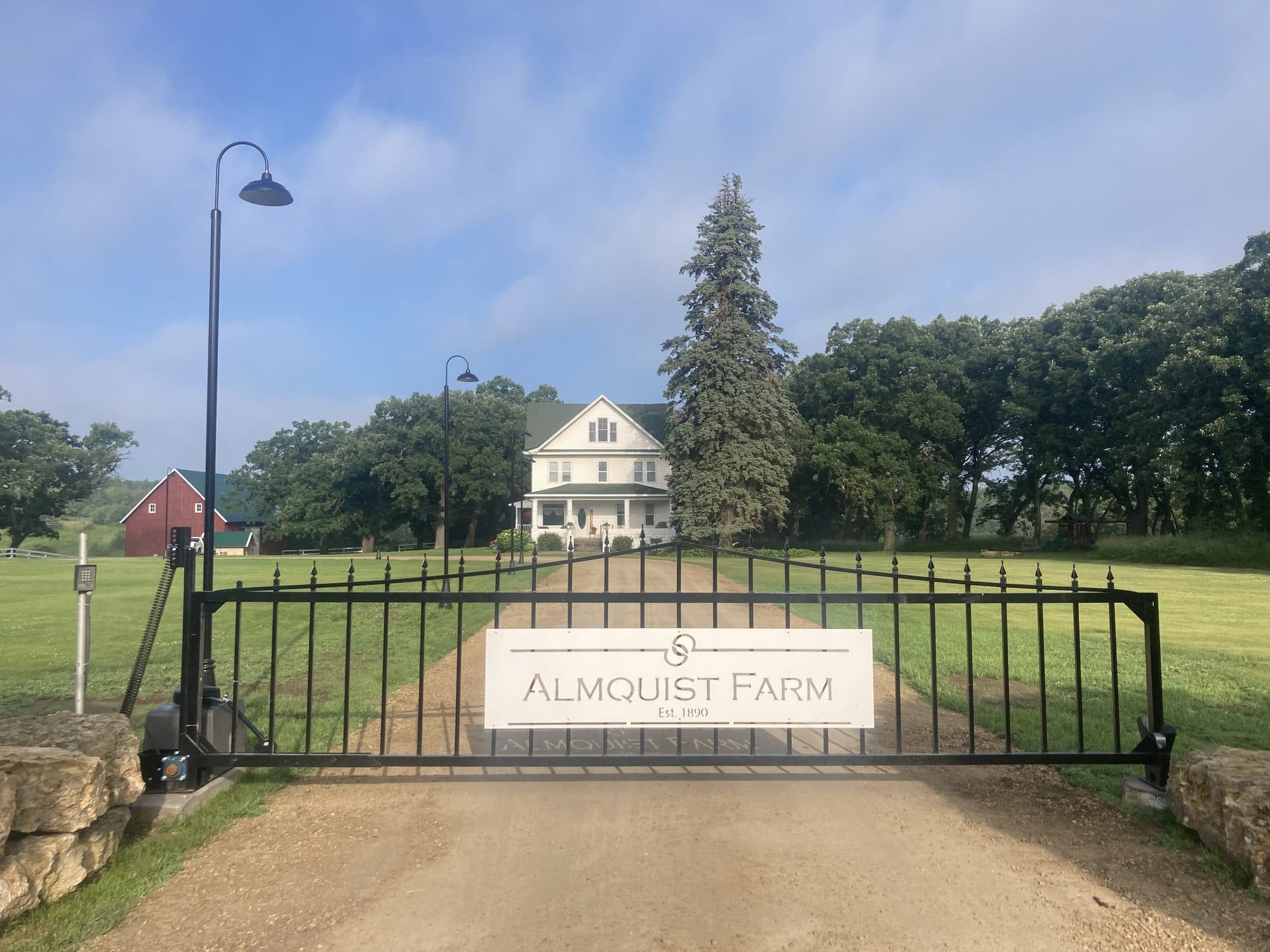 Black iron estate gate with a custom farm name plaque