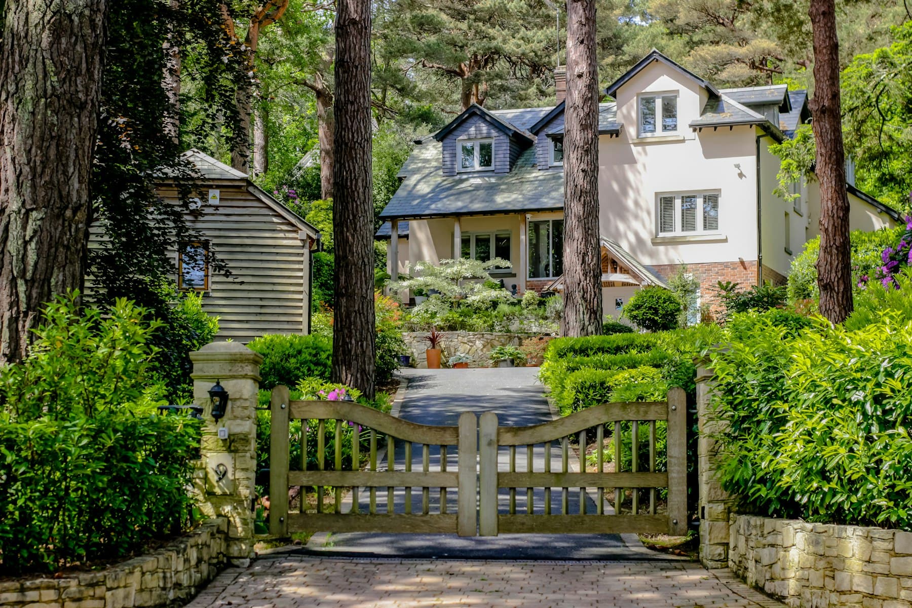 Custom wood double drive gate between stone pillars